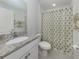 Clean bathroom with modern fixtures, granite countertops, and a shower with palm tree curtain at 2450 Sahara Ln, North Port, FL 34286