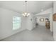 Open dining room with elegant chandelier, neutral paint and tile floors throughout at 2450 Sahara Ln, North Port, FL 34286