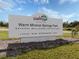 An eye-level view of the North Port Warm Mineral Springs Park entrance sign on a sunny day at 2450 Sahara Ln, North Port, FL 34286