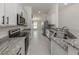 Galley kitchen with stainless appliances, granite counters, and ample cabinet space at 2450 Sahara Ln, North Port, FL 34286