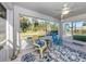 Relaxing screened porch with ceiling fan, colorful chairs and view of the pool and backyard at 2450 Sahara Ln, North Port, FL 34286