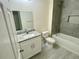 Modern bathroom featuring a granite countertop, gray-tiled shower, and white fixtures at 2643 Orchard Cir, North Port, FL 34288