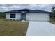 Charming single-story home with a well-manicured lawn and a two-car garage at 2643 Orchard Cir, North Port, FL 34288