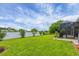 Well-manicured backyard with lush green grass and enclosed lanai, perfect for outdoor enjoyment at 2694 Hopwood Rd, North Port, FL 34287