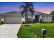 Attractive home with a spacious driveway, attached garage, and vibrant green lawn under a twilight sky at 2694 Hopwood Rd, North Port, FL 34287