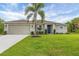 Charming single-story home featuring a manicured lawn, an attached garage, and tasteful landscaping at 2694 Hopwood Rd, North Port, FL 34287