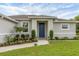 Close-up of a home's front entrance with blue door, walkway, and professionally landscaped garden beds at 2694 Hopwood Rd, North Port, FL 34287
