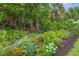 Beautifully landscaped garden with a variety of colorful flowers and lush greenery at 2694 Hopwood Rd, North Port, FL 34287