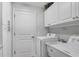 Clean laundry room equipped with white cabinets, washer and dryer, and utility sink at 2694 Hopwood Rd, North Port, FL 34287