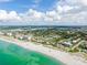 Wonderful aerial view of a beachfront community featuring white sand, turquoise water, and lush greenery at 325 Fiesole St, Venice, FL 34285