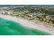Picturesque aerial view of a beachfront community with clear turquoise water, white sand, and nearby homes at 325 Fiesole St, Venice, FL 34285