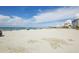 Expansive beach view featuring clear blue skies, turquoise water, and white sand with nearby buildings at 325 Fiesole St, Venice, FL 34285