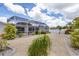 Rear exterior view of a screened patio, gravel yard, and lush tropical landscaping at 325 Fiesole St, Venice, FL 34285