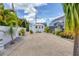Backyard shed with a gravel driveway, lush tropical foliage, and a privacy fence at 325 Fiesole St, Venice, FL 34285