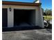 Attached garage with open door and black asphalt driveway on a sunny day at 3641 Longmeadow # 33, Sarasota, FL 34235