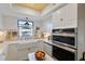 Bright kitchen featuring white cabinets, farmhouse sink, and modern appliances, creating a charming and functional space at 3641 Longmeadow # 33, Sarasota, FL 34235