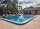 A community pool surrounded by lounge chairs and tropical foliage at 3641 Longmeadow # 33, Sarasota, FL 34235