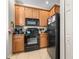 Well-equipped kitchen features wooden cabinetry, black appliances, and a tile floor at 3691 Parkridge Cir # 201, Sarasota, FL 34243