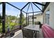 Enclosed lanai featuring a dining table, seating, and view of the fenced backyard at 3818 Willow Walk Dr, Palmetto, FL 34221