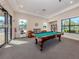 Bright community game room with a pool table, sitting area, and many windows at 4123 Cascade Falls Dr, Sarasota, FL 34243