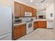 Well-lit kitchen with white appliances, warm wood cabinetry, and a spacious countertop area at 4123 Cascade Falls Dr, Sarasota, FL 34243