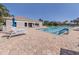 Community pool with a building, umbrellas, lounge chairs, and stamped concrete decking at 4123 Cascade Falls Dr, Sarasota, FL 34243