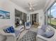 Inviting sunroom with white wicker furniture, tile floor, and lake view at 4123 Cascade Falls Dr, Sarasota, FL 34243