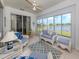 Bright sunroom with large windows, wicker furniture, and lovely lake views at 4123 Cascade Falls Dr, Sarasota, FL 34243