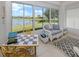 Relaxing sunroom with lake views, wicker furniture, and tiled floors at 4123 Cascade Falls Dr, Sarasota, FL 34243