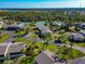 Aerial view of condo community with tennis courts, beautiful mature trees, and lush landscaping at 4260 Placida Rd # 25D, Englewood, FL 34224