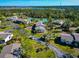 Aerial view of condo community with tennis courts, beautiful mature trees, and lush landscaping at 4260 Placida Rd # 25D, Englewood, FL 34224