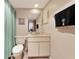A well-lit bathroom featuring a toilet, single sink vanity, and light tile flooring at 4260 Placida Rd # 25D, Englewood, FL 34224