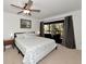 Comfortable bedroom with neutral tones, ceiling fan, and sliding doors to balcony at 4260 Placida Rd # 25D, Englewood, FL 34224