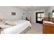 Light bedroom with neutral decor, ceiling fan, and a sliding glass door leading to balcony at 4260 Placida Rd # 25D, Englewood, FL 34224