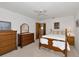 Bright bedroom featuring wood furniture, ceiling fan, and carpeted floor at 4260 Placida Rd # 25D, Englewood, FL 34224