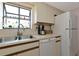 Kitchen with white appliances, tile flooring, and neutral-toned cabinets at 4260 Placida Rd # 25D, Englewood, FL 34224