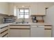 Bright kitchen featuring white cabinets, stainless steel appliances, and a window over the sink at 4260 Placida Rd # 25D, Englewood, FL 34224