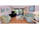 Bright living room with wood floors, comfortable seating, and a peaceful view of the outdoor greenery at 4260 Placida Rd # 25D, Englewood, FL 34224