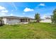 Spacious backyard with a lush green lawn and a screen room, perfect for outdoor activities and relaxation at 427 Canterbury Rd, Venice, FL 34293