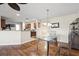 Open-concept layout showcasing the dining area with an elegant glass table set adjacent to the kitchen at 427 Canterbury Rd, Venice, FL 34293