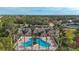 Aerial view of the community pool with beautiful palm trees and luxurious lounge seating near a clubhouse at 4433 Corso Venetia Blvd # C18, Venice, FL 34293