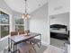 Cozy dining area with modern chandelier, table, and view of the bedroom through an open doorway at 4433 Corso Venetia Blvd # C18, Venice, FL 34293