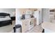 Cozy kitchen featuring white appliances, light wood cabinets, and convenient access to an adjacent bedroom at 4433 Corso Venetia Blvd # C18, Venice, FL 34293