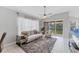 Comfortable living room featuring neutral tones, ample natural light, and sliding doors leading to outdoor patio at 4433 Corso Venetia Blvd # C18, Venice, FL 34293