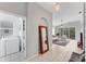 Bright living room with tiled floors, neutral decor, laundry room, and sliding glass doors to patio at 4433 Corso Venetia Blvd # C18, Venice, FL 34293