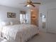 Comfortable bedroom with a ceiling fan, carpet, and a view into the bathroom at 457 Longwood Dr, Venice, FL 34285