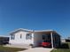 Charming single-story home with carport featuring manicured lawn and mature landscaping at 457 Longwood Dr, Venice, FL 34285