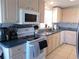 Charming kitchen featuring tiled floors, essential appliances, and ample cabinet space at 457 Longwood Dr, Venice, FL 34285