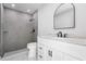 Modern bathroom featuring a tile shower, arched mirror, and white vanity at 4740 Payne St, North Port, FL 34287