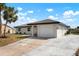 Single-story home featuring a clean white exterior, an attached garage, and a concrete driveway at 4740 Payne St, North Port, FL 34287